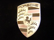 В виде логотипа Porshe для Porsche Club. Нержавеющая сталь с цветной лазерной гравировкой