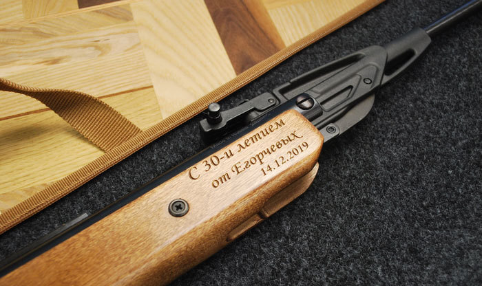 Глубокая лазерная гравировка памятного текста на деревянном корпусе пневматического оружия